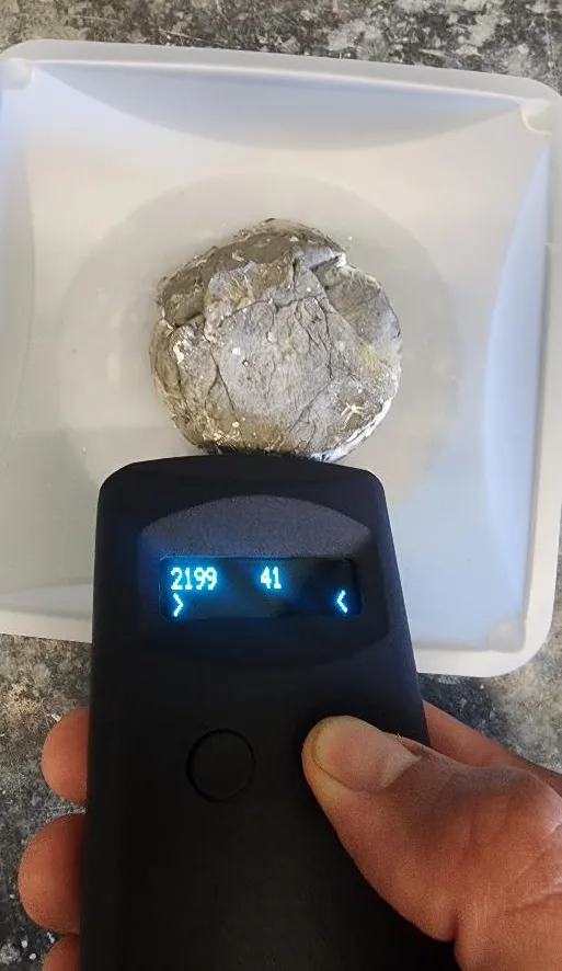 A handheld reader measuring a remelted aluminum sample