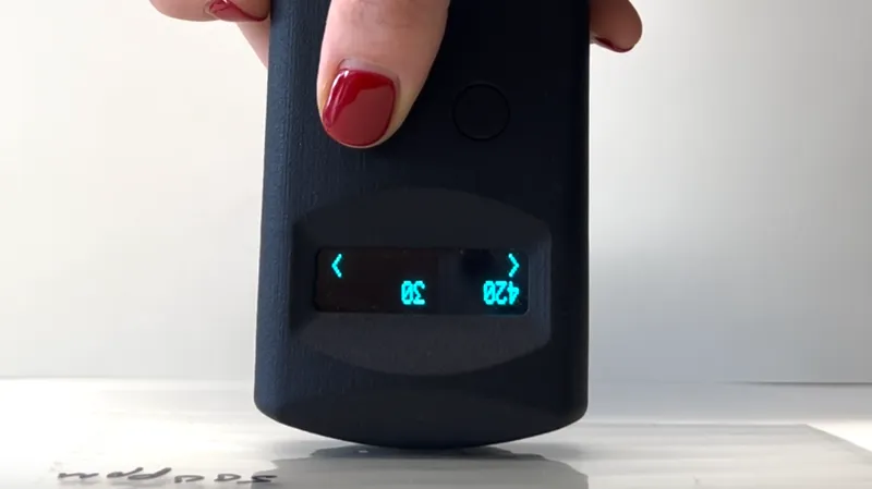 A handheld reader measuring a stack of tagged plastic sheets