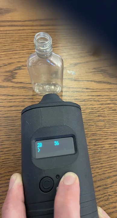 The same reader beside a tagged 50 mL bottle, showing a signal